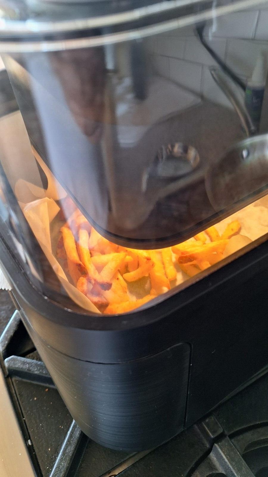 Close-up of fries in the Ricardo air fryer's lower basket through the glass lid